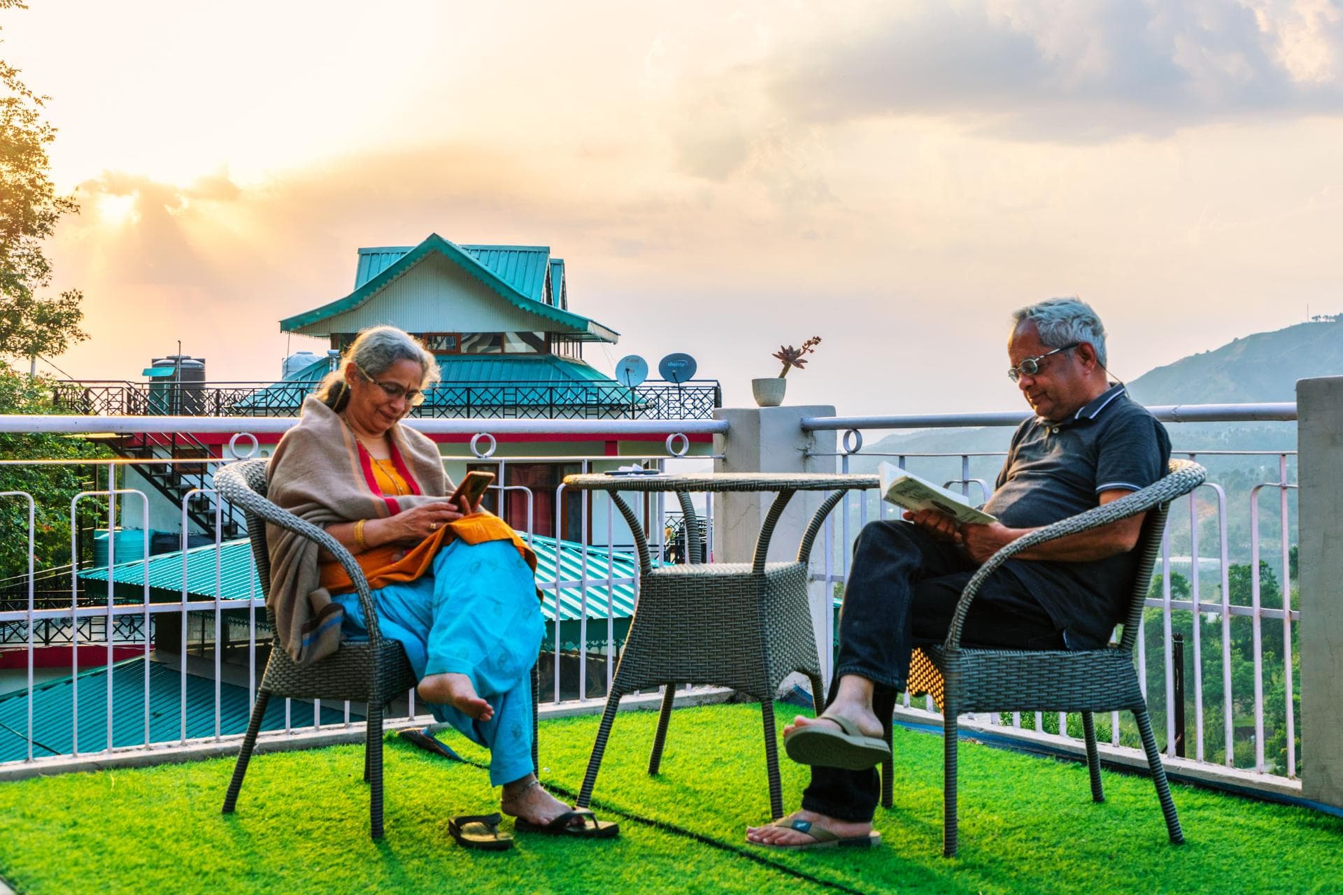 Guests relaxing at Mohija Homestay near Shimla, one reading a book and another browsing on a phone